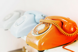 Vintage rotary phones in orange and light blue, showcasing nostalgic design elements related to home comfort and maintenance.