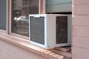 Window HVAC unit installed in a brick wall, illustrating energy-efficient cooling solutions for homes, relevant to holiday decoration ideas for HVAC systems.