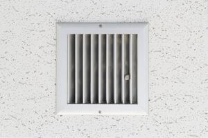 Air vent grille on a textured ceiling, highlighting the importance of vent cleaning for improved indoor air quality and allergen reduction during allergy season.