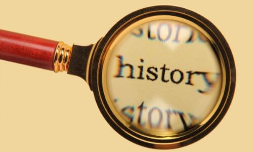 Magnifying glass focusing on the word "history," symbolizing the exploration of air conditioning's historical significance.