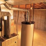 Cylindrical water heater and furnace in an industrial basement, highlighting essential HVAC installation components.