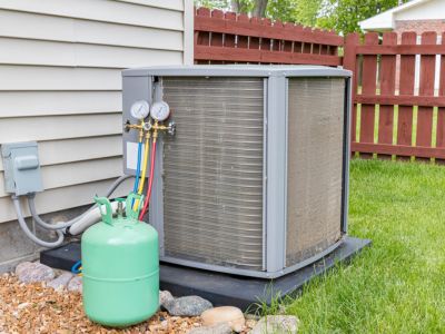 Air conditioning unit with refrigerant tank and pressure gauges, highlighting the importance of regular maintenance for efficiency and reduced repair needs.