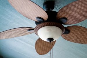 Ceiling fan with five wooden blades, designed for air circulation and cooling, relevant to tips on enhancing sleep quality and reducing humidity in homes.
