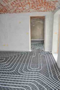 Under-the-floor radiant heating system installation with visible piping layout in a residential space, illustrating efficient heating solutions for homes.