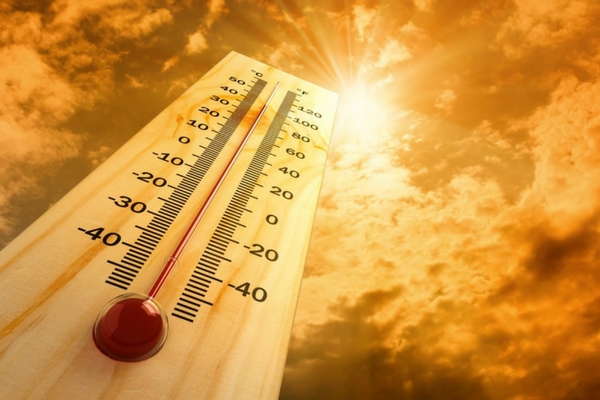 Thermometer displaying temperature against a bright, cloudy sky, illustrating the importance of temperature control for optimal sleep quality.