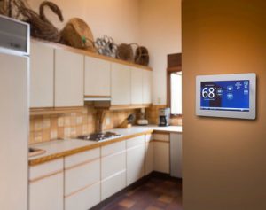 Smart thermostat displaying 68°F in a modern kitchen, emphasizing HVAC efficiency and comfort for winter heating solutions.